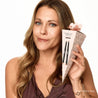 Woman holding a makeup product packaging with 'Pecan Praline Duo' text on a white background