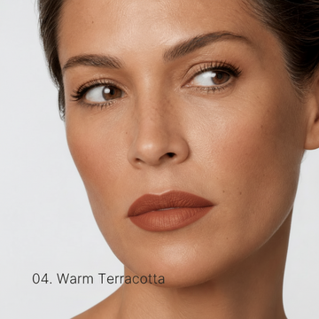 Close-up of a woman's face with Warm Terracotta makeup on a light gray background