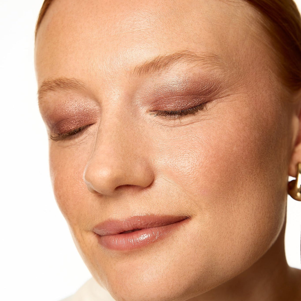 Close-up of a person with soft makeup on a white background