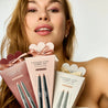 Woman holding Coulure eyeshadow stick products with a neutral background