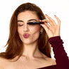 Woman applying makeup with a brush on a white background