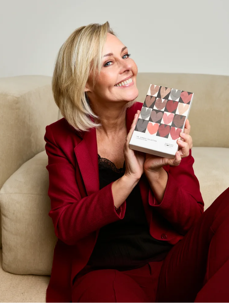 Woman holding a makeup palette on a beige couch