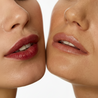 Close-up of two women's lips with a neutral background