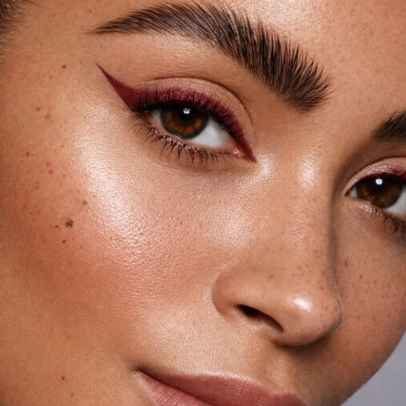 Close-up of a woman's face with makeup on a neutral background